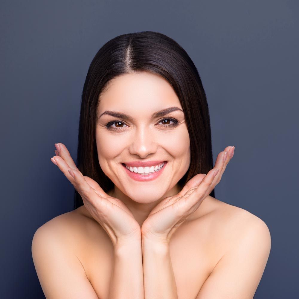 Smiling woman framing face with her hands