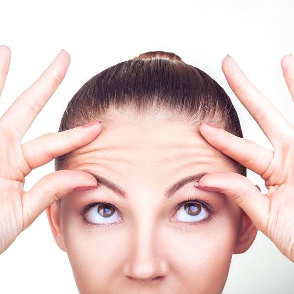 Woman touching forehead